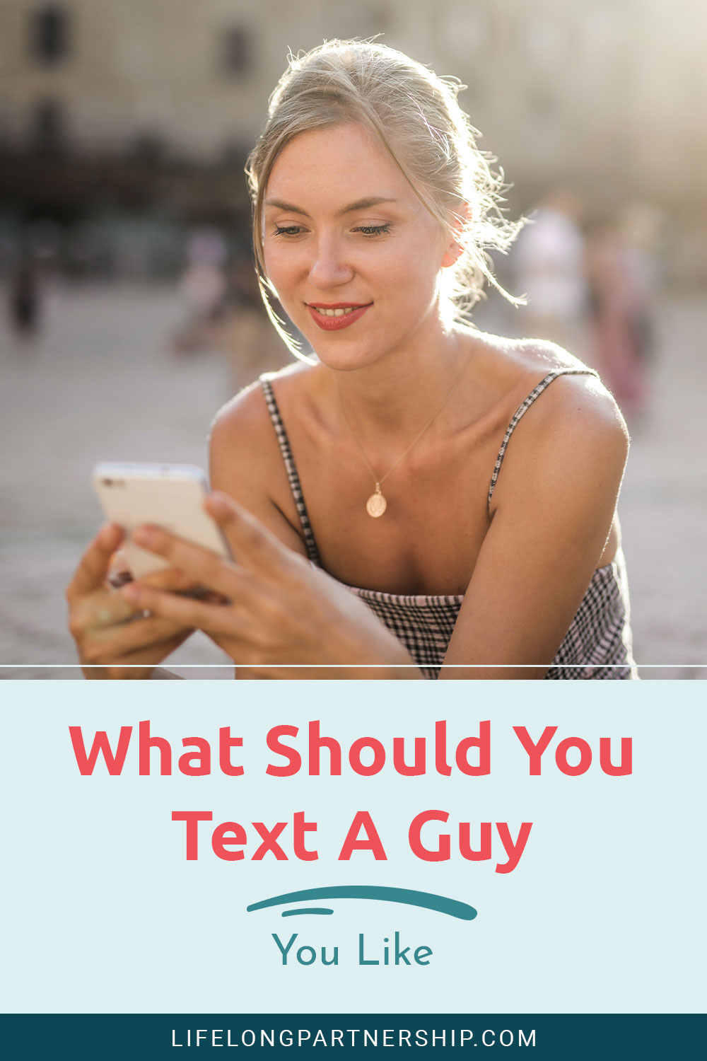 Woman texting on phone and smiling - What Should You Text A Guy You Like